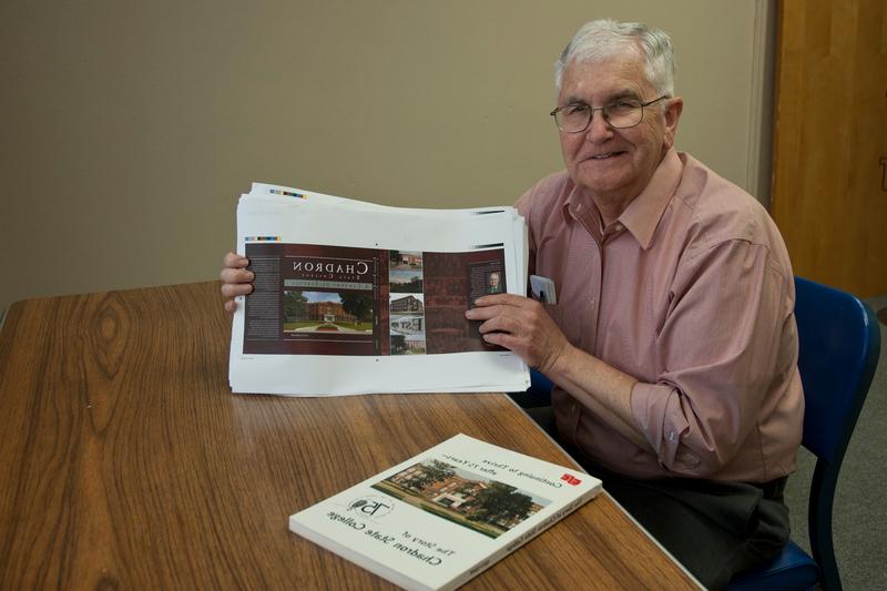 Con Marshall displays a proof copy of the centennial history book as a copy of the 75th anniversary book is shown in the foreground.